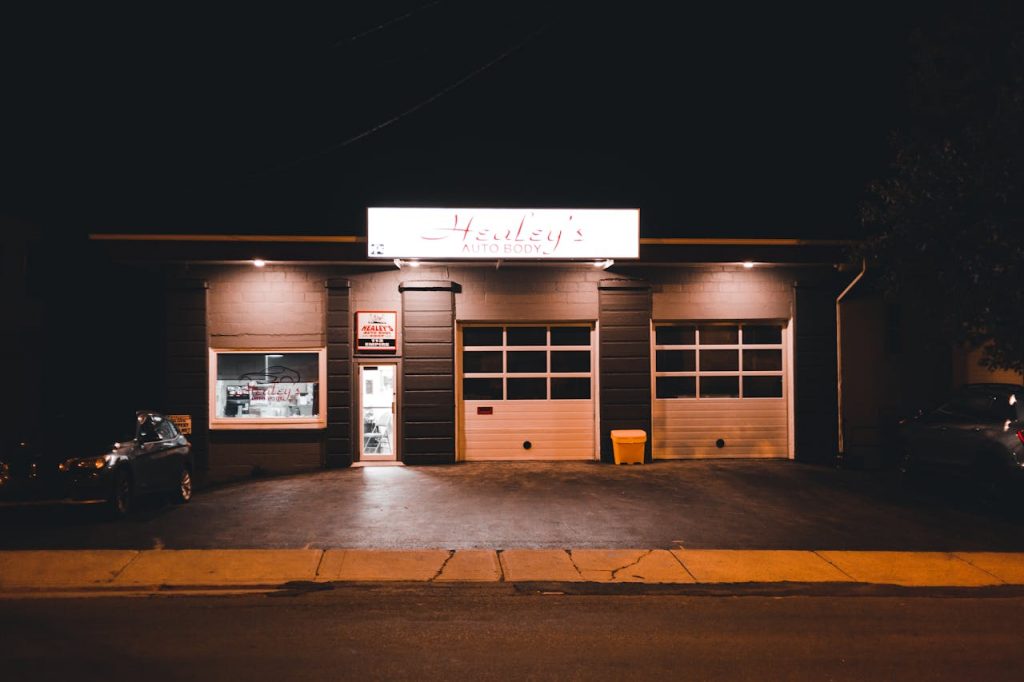 Illuminated exterior view of an auto body shop at night with a minimalistic facade.